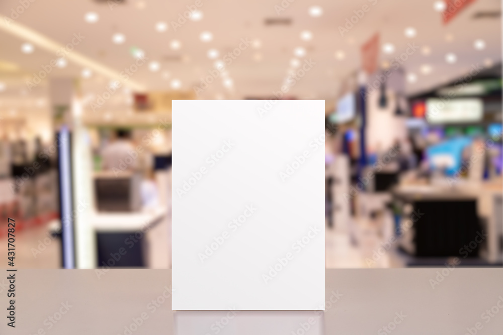 Mock up Label the blank menu frame in shopping mall, Stand for booklets with white sheets paper table cafeteria blurred background can inserting the text of the customer. Mock up Label the blank menu frame in shopping mall, Stand for booklets with white sheets paper table cafeteria blurred background can inserting the text of the customer.