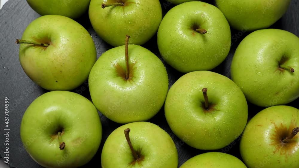 A lot of green apples rotating, closeup. Fruits background A lot of green apples rotating, closeup. Fruits background