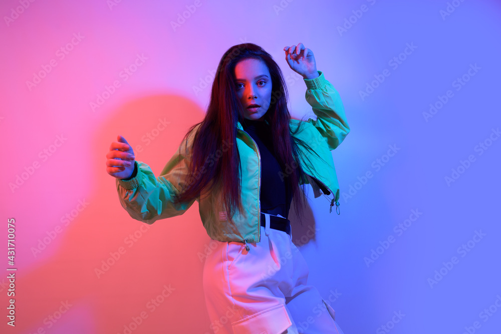 The brunette dancers in neon, the dancer in red and blue lights. Hip hop  party, smile. Model in flight, jumping. Bright photo, emotions.