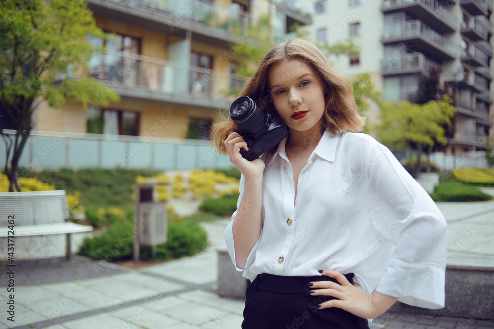 A beautiful girl looks in the viewfinder in the camera, and takes pictures. The blonde learns to photograph and earn money on the photo. A girl photographer walks around the city and takes pictures A beautiful girl looks in the viewfinder in the camera, and takes pictures. The blonde learns to photograph and earn money on the photo. A girl photographer walks around the city and takes pictures