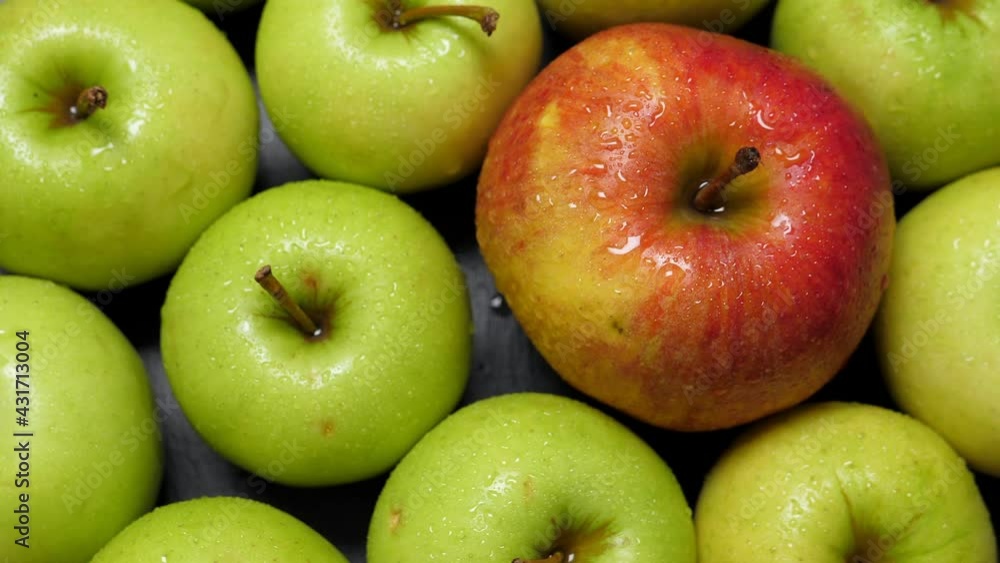 One red and many green apples rotating, closeup. Fruits background One red and many green apples rotating, closeup. Fruits background