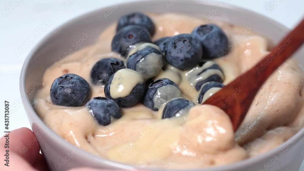 Banana dairy-free ice cream or vegan smoothie bowl with berries and tahini, white table. Banana dairy-free ice cream or vegan smoothie bowl with berries and tahini, white table.