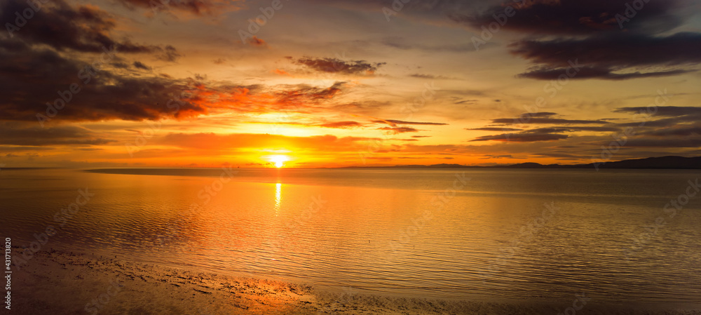 Fototapeta premium Beautiful sunset colors over the coastline of Allerdale district in Cumbria, UK. Sun setting over the shore of Allonby bay on autumn.