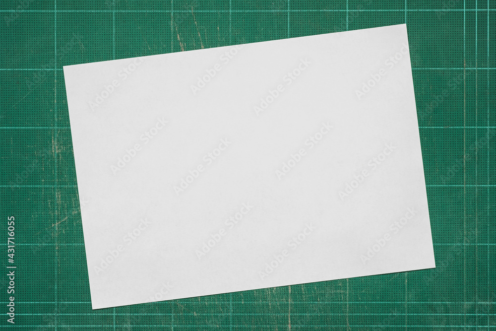 Top view of empty white paper A4 size on old grunge green dirty cutting mat, copy space for text and graphic. Top view of empty white paper A4 size on old grunge green dirty cutting mat, copy space for text and graphic.