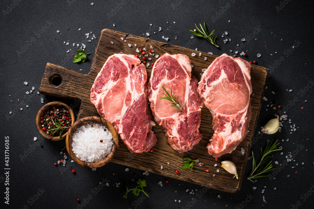 Pork meat at wooden board on black table. Pork meat at wooden board on black table.