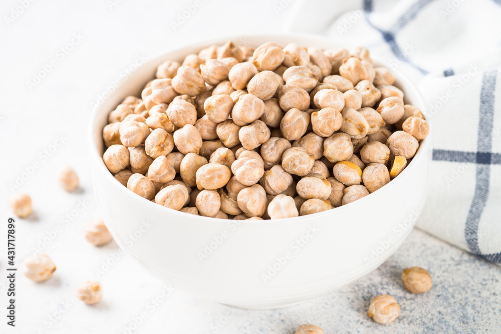Chickpeas in white bowl at light kitchen table. Chickpeas in white bowl at light kitchen table.