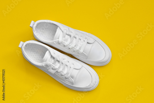 white sneakers isolated on a yellow background. Element for design. Sport shoes. 