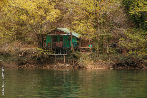 An old hut on the banks of a mountain river, among the gorge.