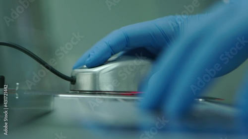 Hand of a doctor in protective gloves using mouse. Health and medicine concept