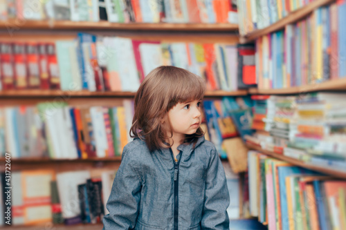 Happy Playful Toddler Girl Standing in a Library