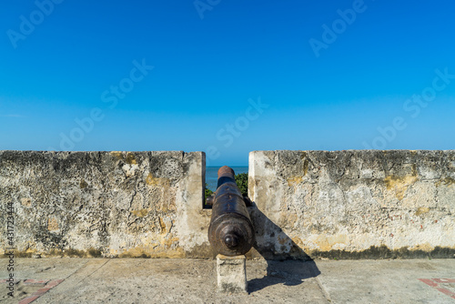 A lone canon peaks out from an old wall fortification in Cartagena, Colombia