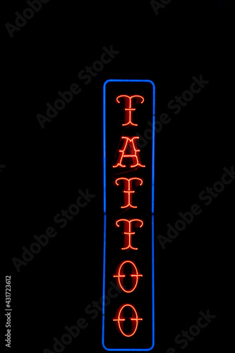 Isolated red and blue neon tattoo sign on black background