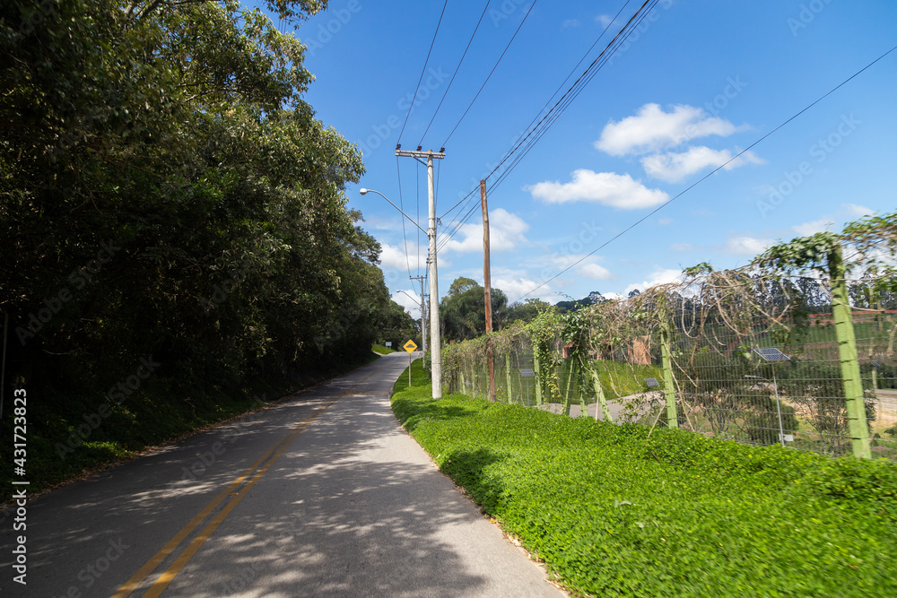 Fototapeta premium Asphalt road with houses next to it and solar energy plates.