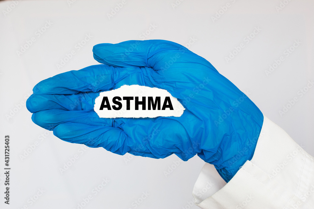 the doctor in gloves holds a card with the text ASTHMA . white background. the medicine the doctor in gloves holds a card with the text ASTHMA . white background. the medicine