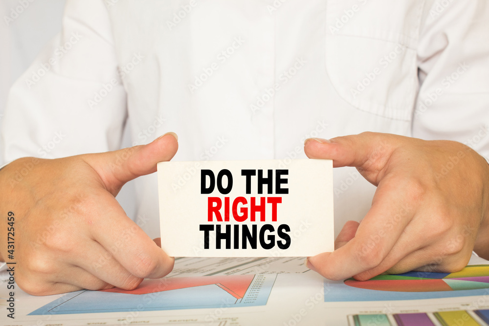 The businessman shows a map with the text DO THE RIGHT THINGS . business concept The businessman shows a map with the text DO THE RIGHT THINGS . business concept