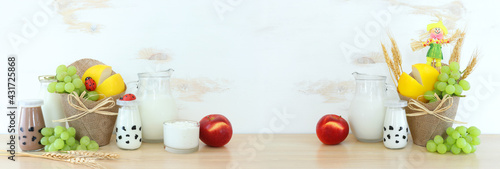 Photo of dairy products over wooden table. Symbols of jewish holiday - Shavuot