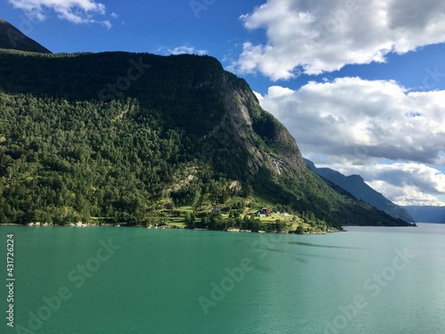 Norwegian Fjords Mountain Hills. Cloudy Blue Sky And Emerald Green Water, Forests And Rocks. Scenic View From Cruise Ship Deck