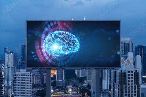 Brain hologram on billboard with Kuala Lumpur cityscape background at night time. Street advertising poster. Front view. KL is the largest science hub in Malaysia, Asia. Coding and high-tech science.