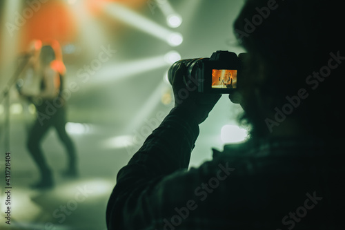 Silhouette of a photographer taking shots during a concert photo