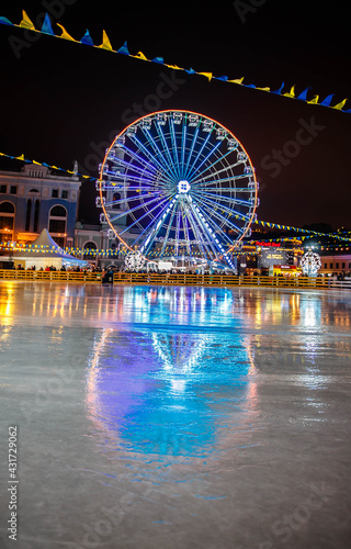 Kiev, Ukraine - January 2021: Ferris wheel and city skating rink at the Christmas fair - Kontraktova Square on Podil in Kiev