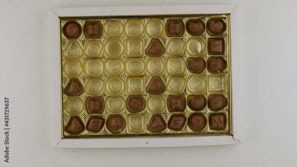 Taking pieces of candy from box of bonbon Taking pieces of candy from box of bonbon