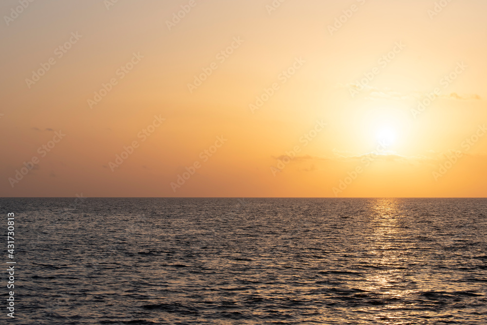 Background and scenic image with horizon of the sun setting on the sea