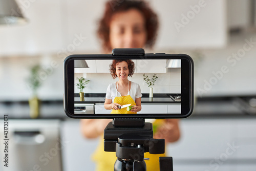 Fototapeta Young blogger and online influencer recording video content on healthy food