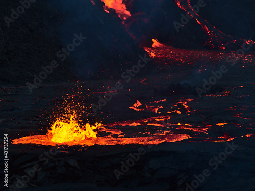 Closeup view of volcano eruption in Geldingadalir valley near Fagradalsfjall mountain, Grindavík, Reykjanes peninsula, southwest Iceland with flowing and spraying lava in the evening.