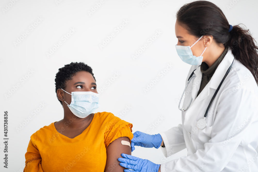 African female getting vaccine against Covid-19 on white background