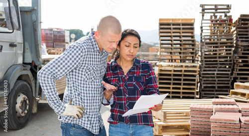 Woman manager giving instructions to a worker at the construction site of a construction store