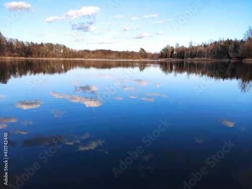 Crystal clear lake reflecting lightly clouded blue sky