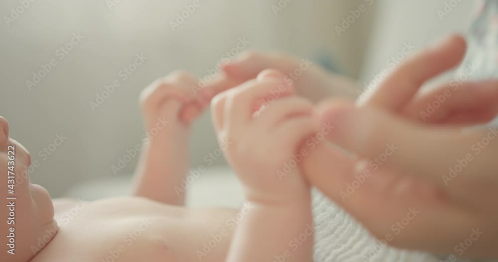 Holding newborns hand in Slow Motion . Happy Family Mother and her Newborn Baby together. Maternity concept. Parenthood. Motherhood. Holding newborns hand in Slow Motion . Happy Family Mother and her Newborn Baby together. Maternity concept. Parenthood. Motherhood.