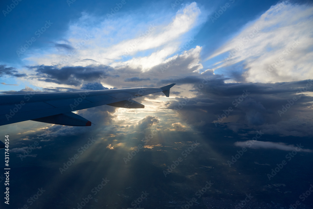 View from the window of an airplane sunbeams through the clouds. Colombia