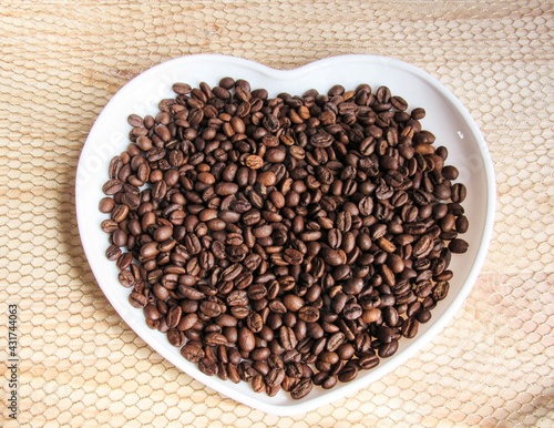 coffee beans on a white heart-shaped plate