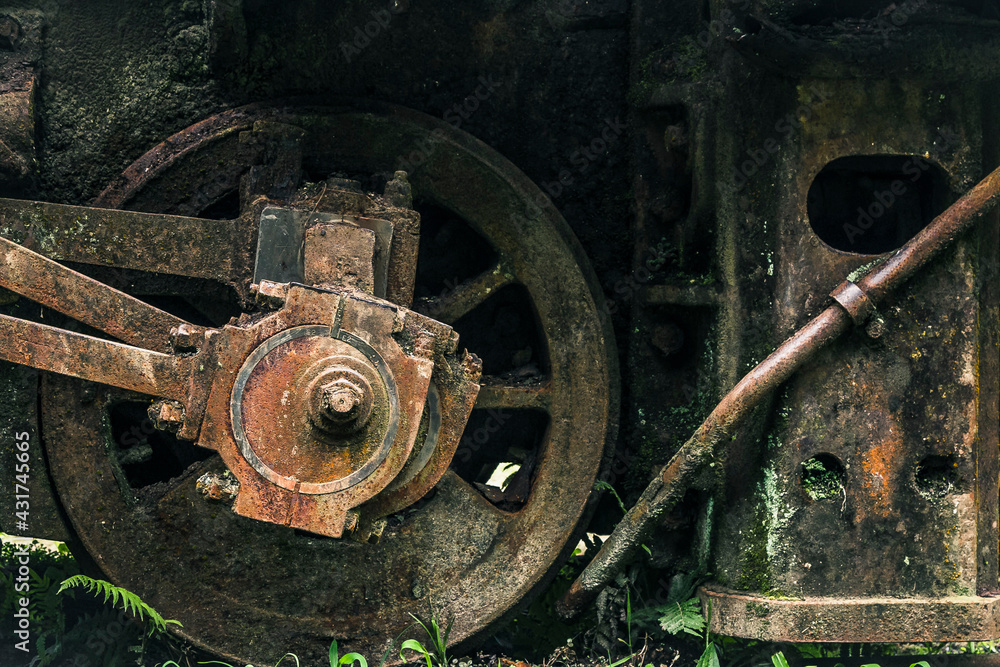 Locomotive wheel made of rusty metal, with a little bit of moss. Locomotive wheel made of rusty metal, with a little bit of moss.