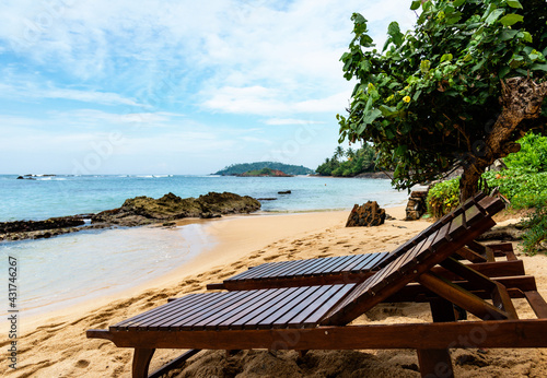 Holidays in tropics  two sun loungers on sandy beach
