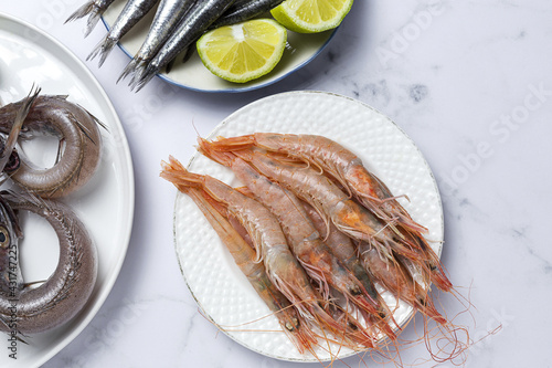 Anchovies, prawns and raw whiting prepared for frying.
