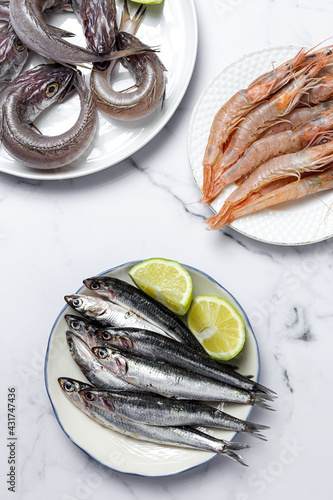 Anchovies, prawns and raw whiting prepared for frying. photo