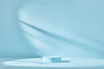 Blue background for product presentation with shadows and light. Empty round podium. Mockup.