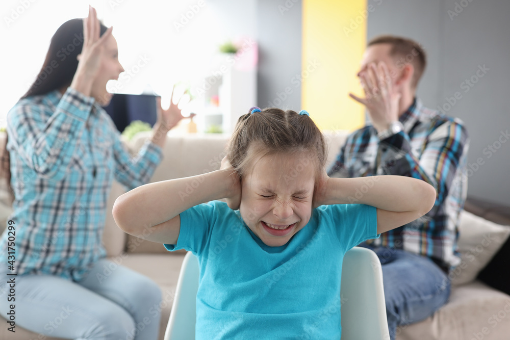 Obraz premium Llittle girl in fear closes her ears so as not to hear her parents swear