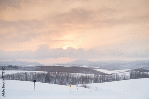 Tokachidake, Biei, Hokkaido, Japan, the warm yellow sunset and snow-white hills are amazing