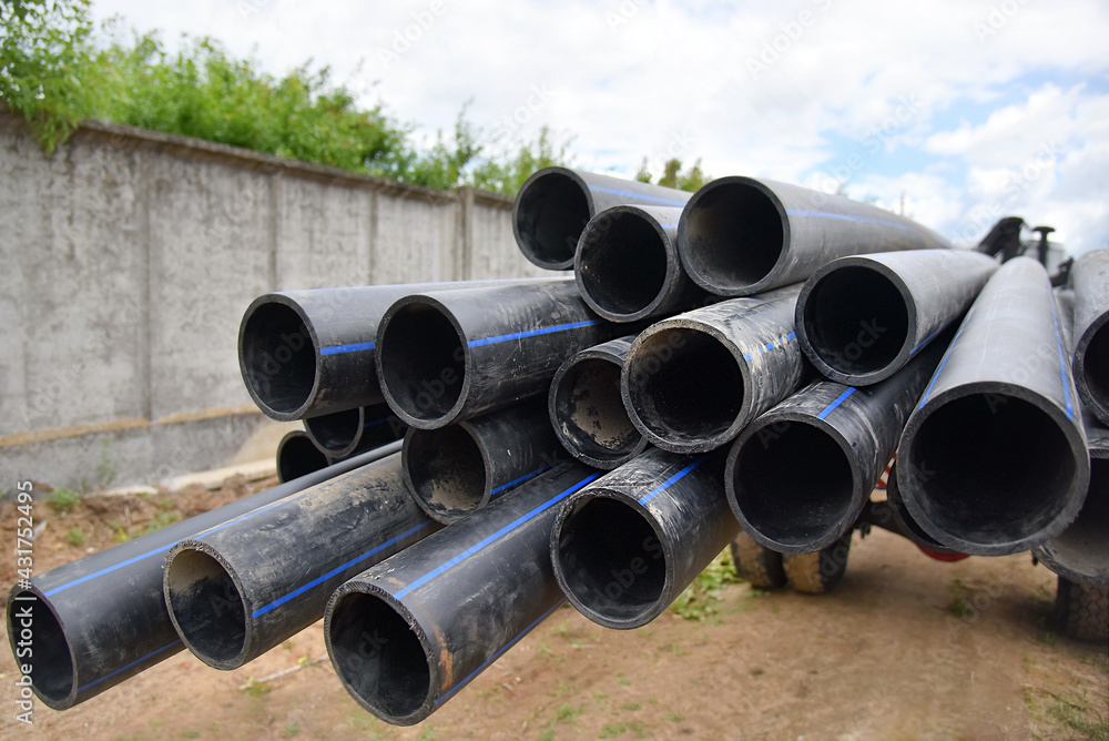 Plastic water pipes are piled up on a truck, close-up. Plastic water pipes are piled up on a truck, close-up.