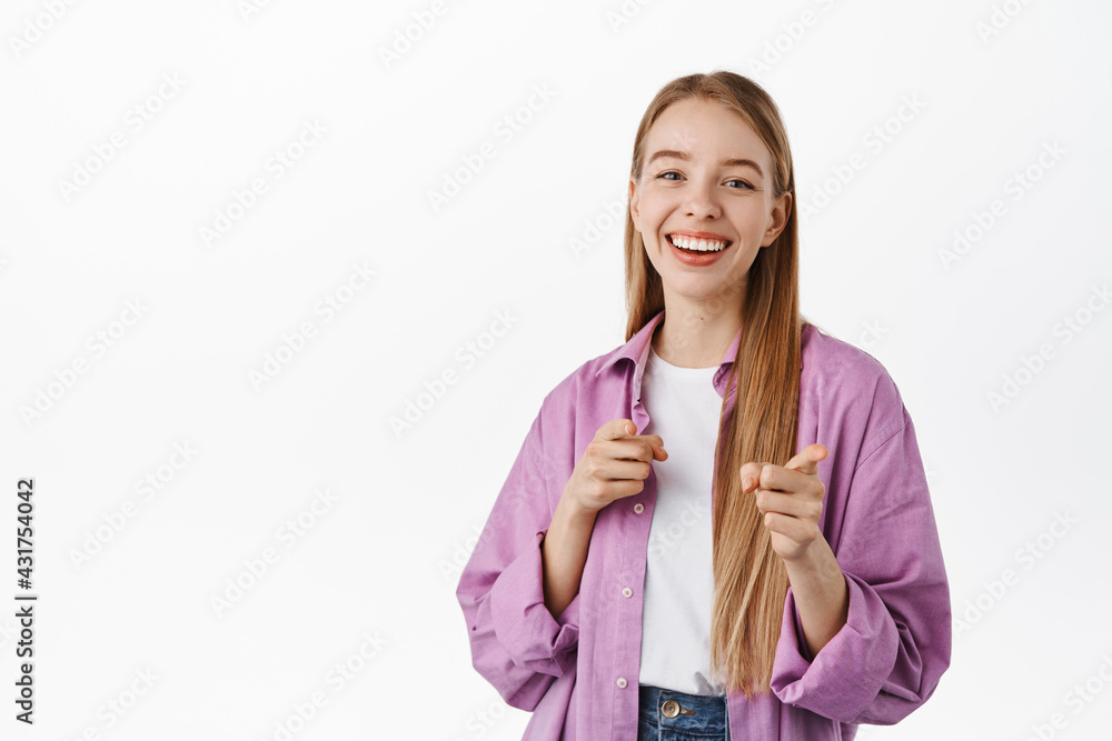 You got this. Smiling positive girl, pointing fingers at camera, inviting, picking someone, praising your efforts, standing against white background You got this. Smiling positive girl, pointing fingers at camera, inviting, picking someone, praising your efforts, standing against white background