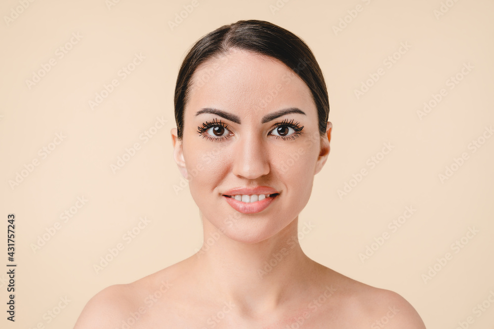 Pretty young caucasian woman with bare shoulders on beautician spa relax face skin care procedures. Beautiful white naked woman with clean skin isolated on beige background Pretty young caucasian woman with bare shoulders on beautician spa relax face skin care procedures. Beautiful white naked woman with clean skin isolated on beige background