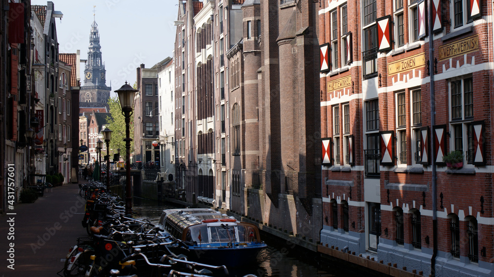 Amsterdam, Netherlands, April 2011: A cityscape of water street and normal street, with boat and bicycle parking.
