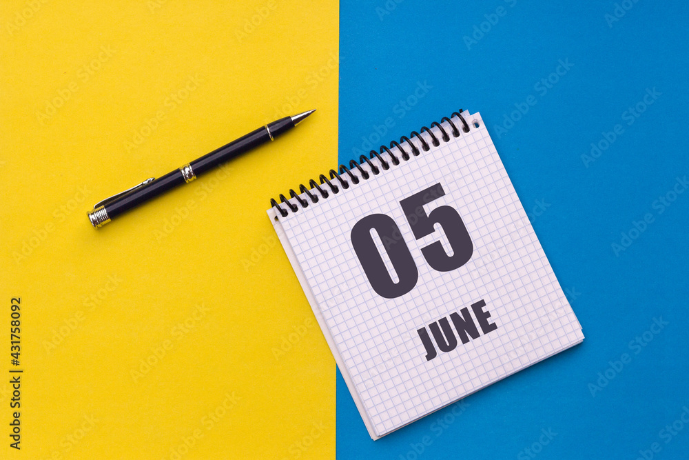 June 5th. Day 5 of month, calendar date. Notebook with a spiral and pen lies on a yellow-blue background June 5th. Day 5 of month, calendar date. Notebook with a spiral and pen lies on a yellow-blue background