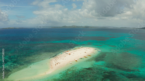 Beautiful beach on tropical island surrounded by coral reef, sandy bar with tourists, top view. Naked Island, Siargao.