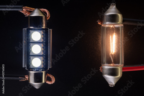 Conventional tungsten halogen bulb with light emitting diode, accessories and components. Lights up, working condition. Black background close-up view. 12V w5w