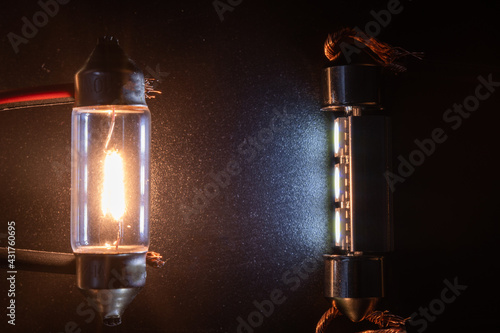 Conventional tungsten halogen bulb with light emitting diode, accessories and components. Lights up, working condition. Black background close-up view. 12V w5w photo