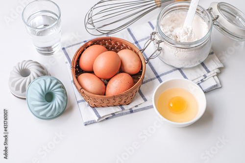 Top view photo of eggs and baking ingredients on white background